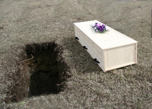 pine casket and grave