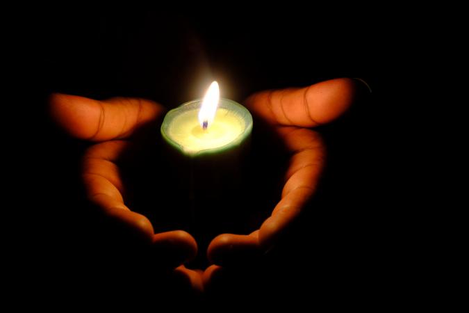Hands holding a candle