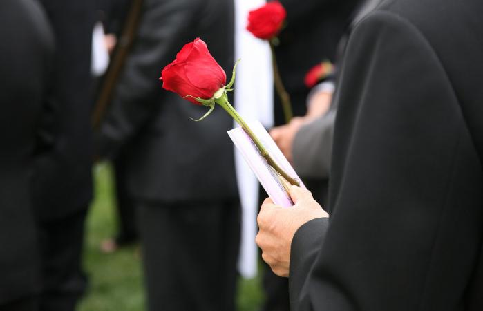Man holding a funeral program