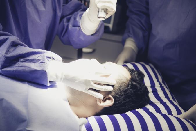 Surgeon shining light in patient's eyes