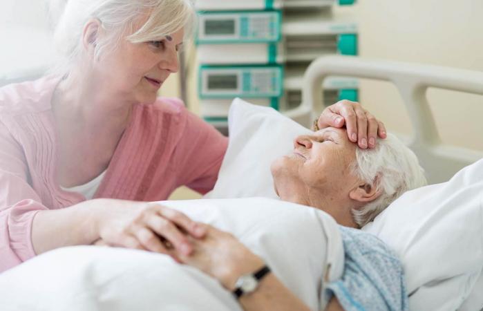 Daughter visiting her senior mother in hospital
