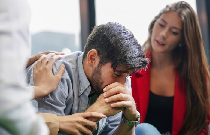 Friends consoling and caring for a person