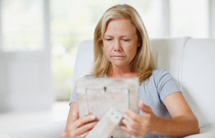 Frowning woman looking at picture frame