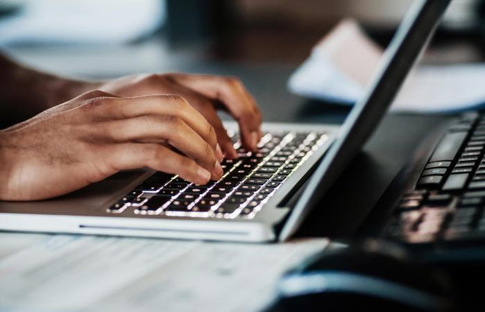 man typing on his laptop