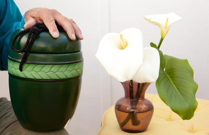 Cremation urn and flowers in a vase