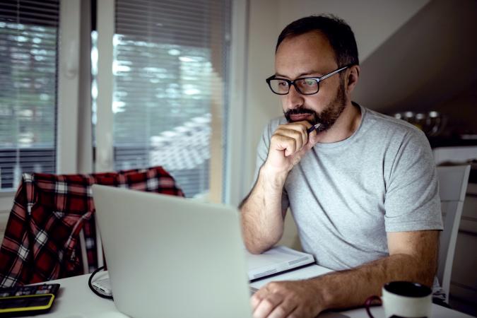 Sad man writing in the computer
