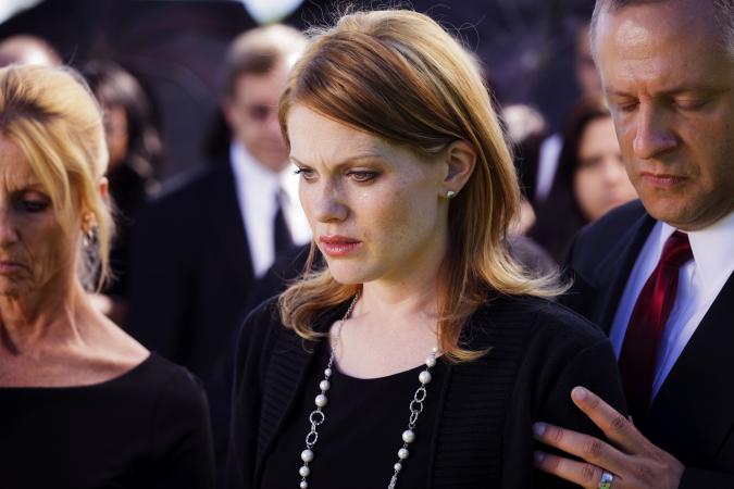A grieving widow standing in a funeral