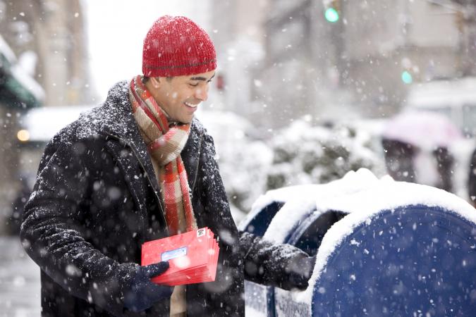 Man mailing Christmas cards in city