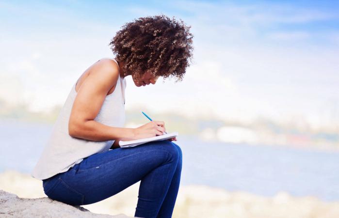 Woman writing in a notebook outdoors