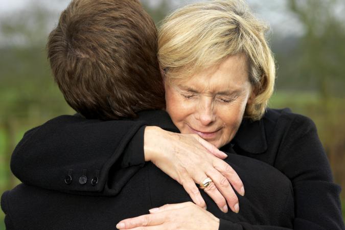 Crying Woman Hugging a Man Before a Funeral