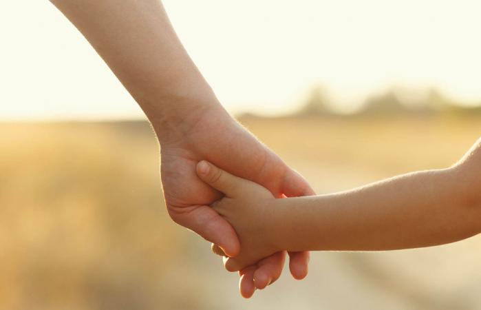 Father holds daughter by the hand