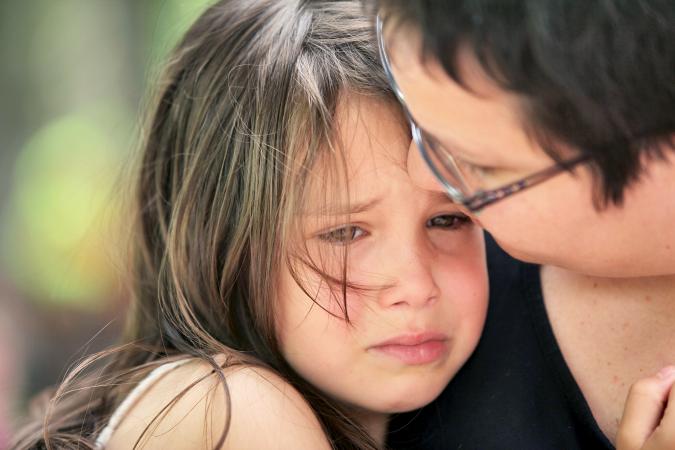 Mother comforting teary young girl
