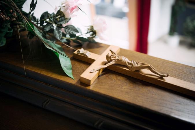 Cross on a wooden casket at a funeral