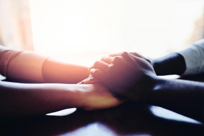 Two people holding hands in comfort