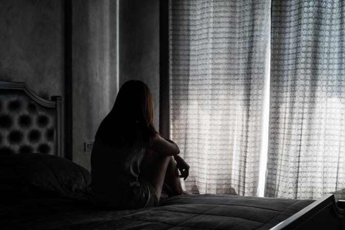 Woman sitting alone in dark room