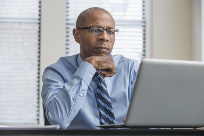 Man with pensive look working on laptop