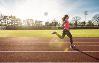 Joven atleta femenina corriendo en la pista