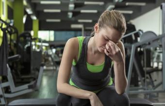 Mujer teniendo dolor de cabeza en el gimnasio