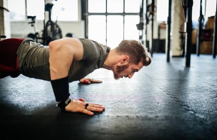 Hombre haciendo flexiones en el gimnasio