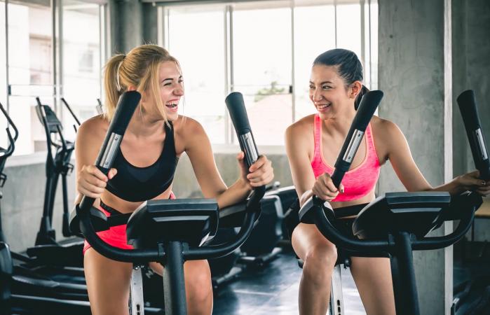 Mujeres en bicicletas estáticas en el gimnasio