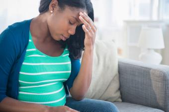 Anxious pregnant woman rubbing forehead