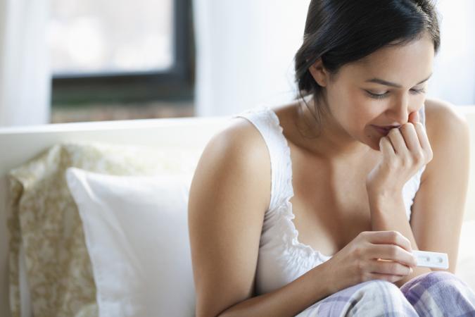 una mujer y una prueba de embarazo positivo