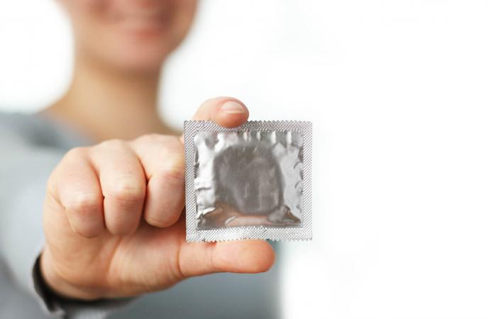 Mujer sosteniendo condón