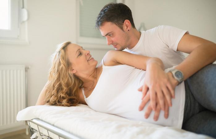 Pareja embarazada en la cama