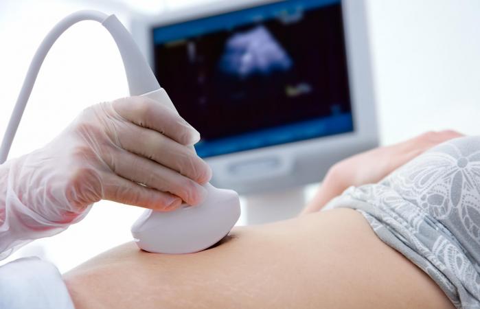 Mujer embarazada recibiendo ecografía del médico