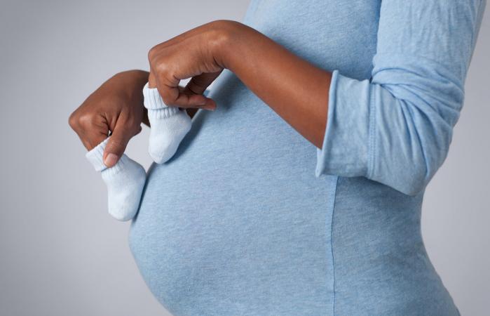 Mujer embarazada con calcetines de bebé