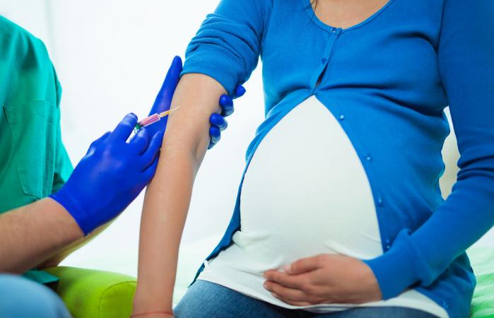 Doctor vacunando a mujer embarazada