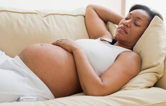 Mujer embarazada durmiendo de espalda