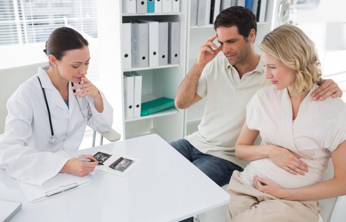Pareja y médico discutiendo sobre informes