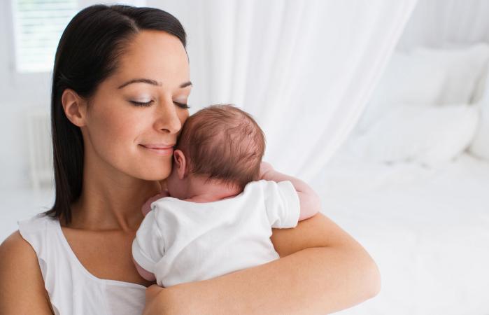 Madre sonriente con bebé recién nacido