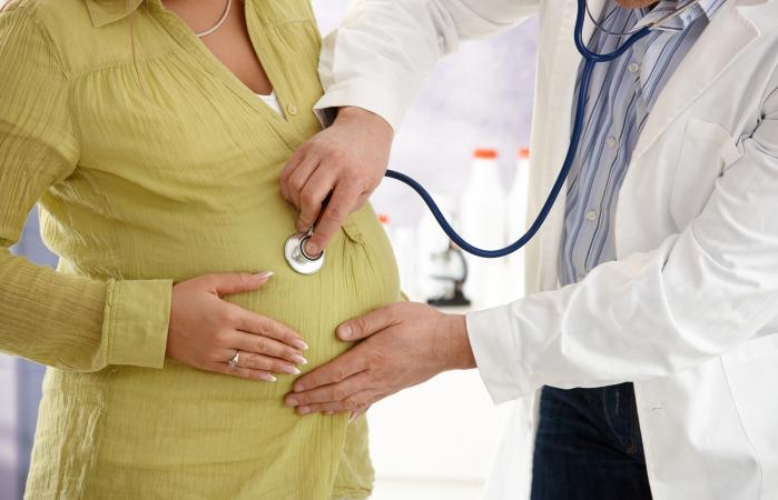 Doctor revisando mujer embarazada con estetoscopio