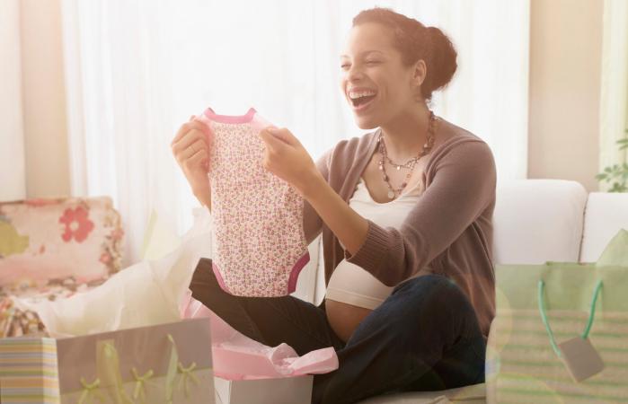 Mujer embarazada abriendo regalos en el baby shower