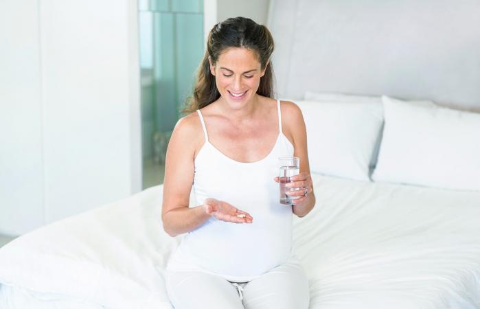 Mujer embarazada tomando antibióticos