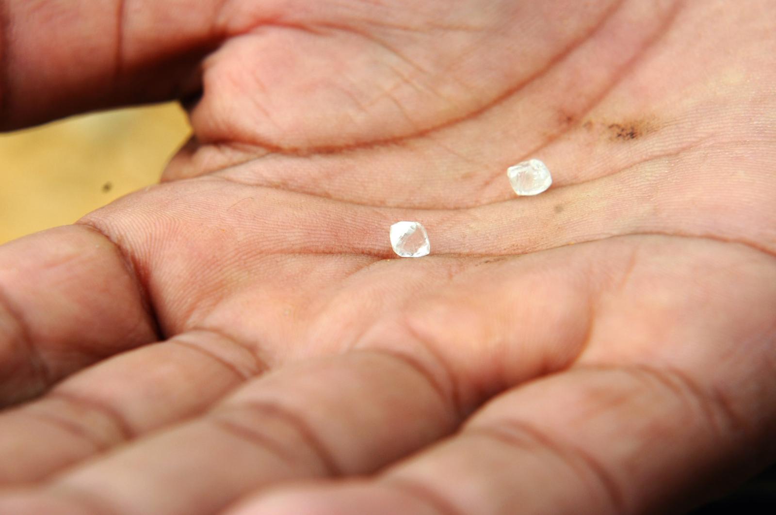 Illegal miner displaying two diamonds he digged out