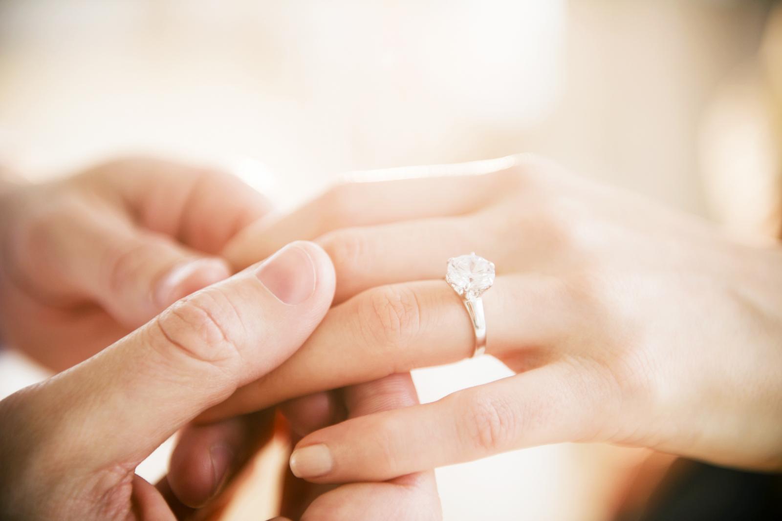 Man's and woman's hands with engagement ring