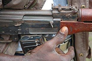 Image of a man's hand on a rifle