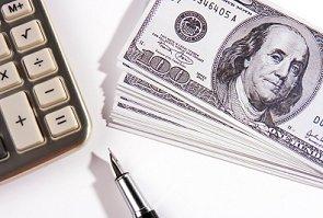 Calculator, stack of $100 bills and a pen