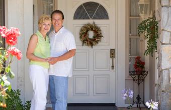 Pareja de pie fuera de su casa