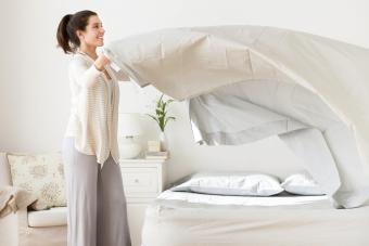 Mujer haciendo la cama en la habitación