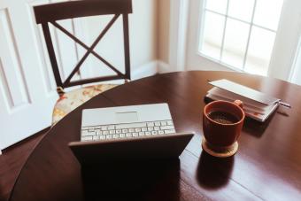 Ordenador, café y agenda encima de una mesa