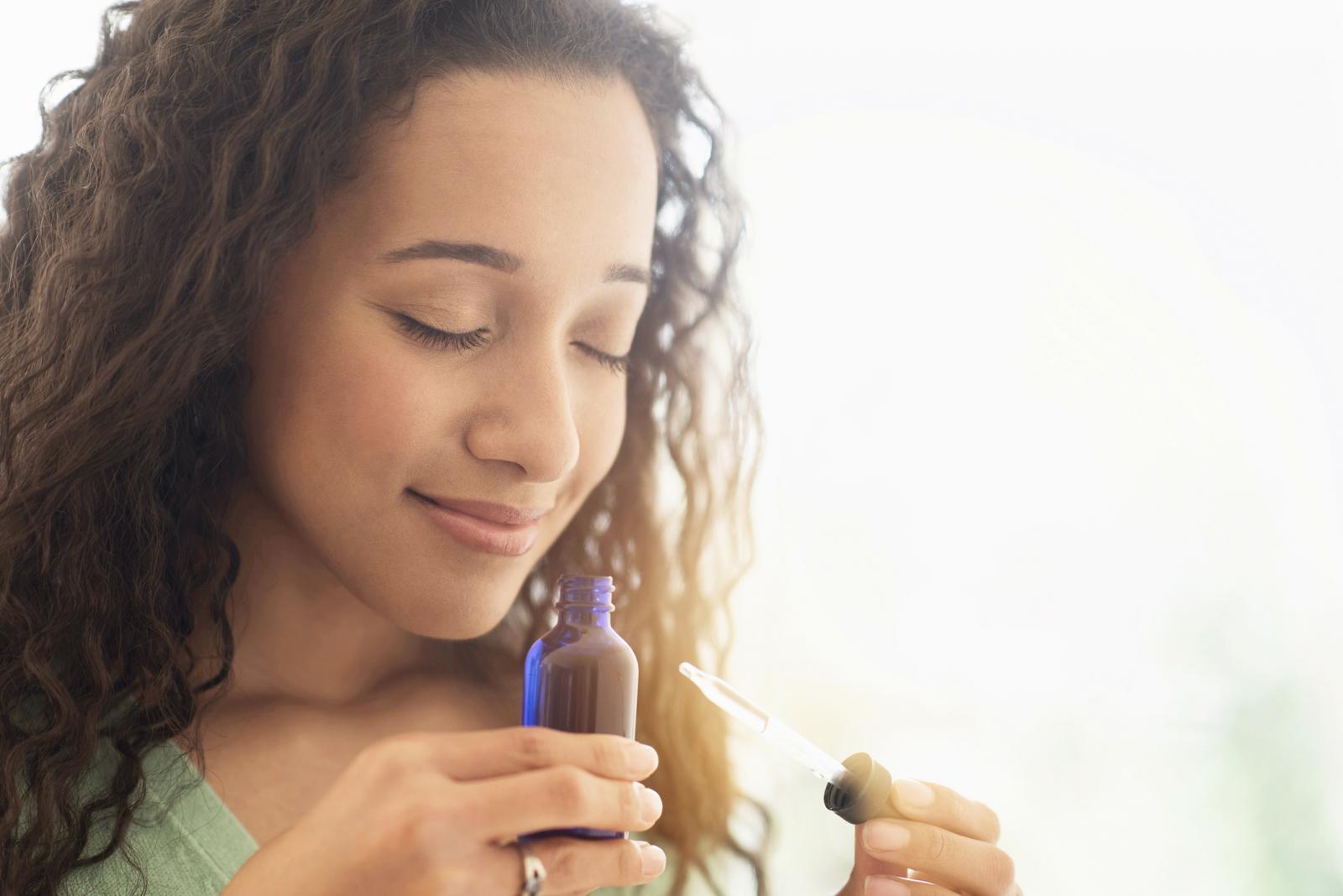 Mujer oliendo un aceite esencial