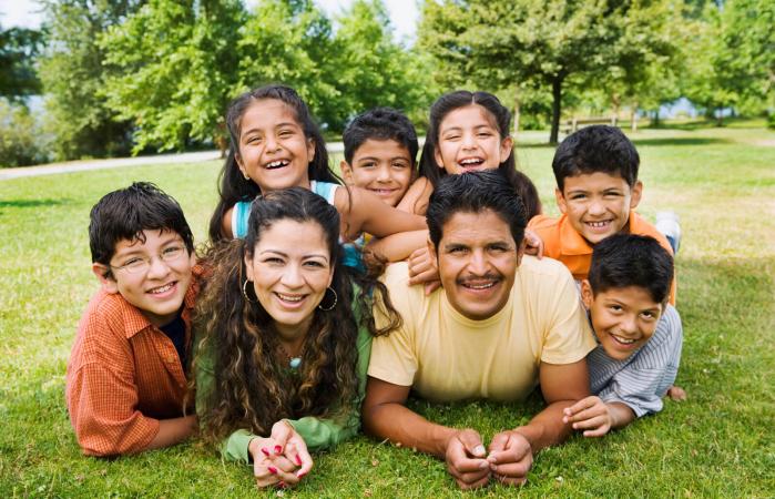 Familia tumbada sobre el césped posa