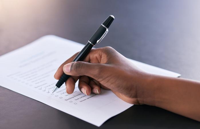 mujer marcando las tareas completadas en una lista de tareas