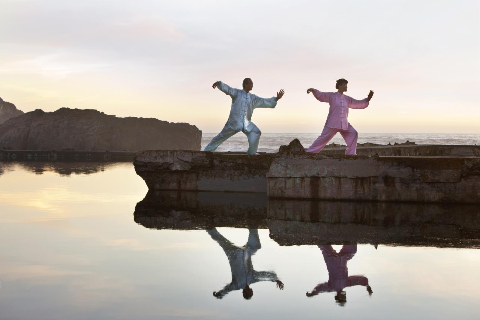 Mujer y hombre praticando Tai Chi afuera