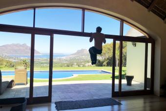 Young man uses a door frame for pull ups in his home