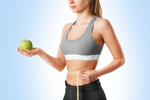 Young woman measuring her waist